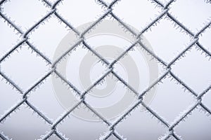 Metal wire fence covered with snow. Cold temperatures. Winter scenery