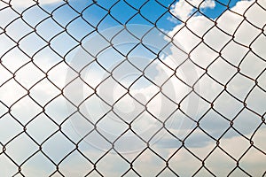 Metal wire-mesh rabitz on a blue cloudy sky background