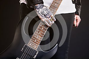 Metal, woman and guitar on black background for punk culture or grunge, edgy and goth fashion with closeup. Rock star