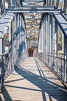 Metal and wooden bridge over a river on a sunny day