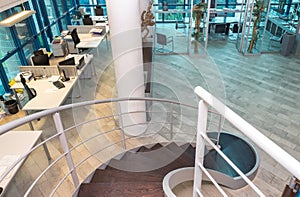 Metal and wooden spiral staircase in modern business office interior