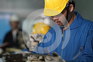 Metal work factory worker working with lathe machine in lathe workshop