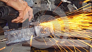 Metal worker grinding in auto body repair shop