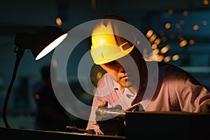 Metal worker looking on Workpiece in workshop