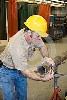 Metal Worker Measures Pipe