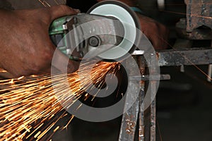 Metal works. Electric wheel grinding on steel structure in factory