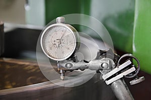 Metal workshop machine, dial gauge instrument measures inclination of cogwheel gear