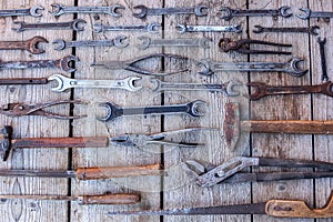 Metal wrench rusty tools lying on a black wooden table. Hammer, chisel, hacksaw, metal wrench. Dirty set of hand tools on a wooden