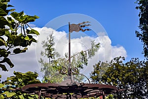Metal wrought iron gazebo with flag developing on the roof