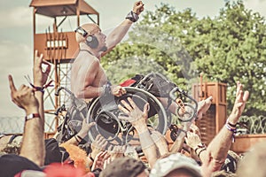 Metalhead in wheelchair during a crowdsurfing at a metal concert