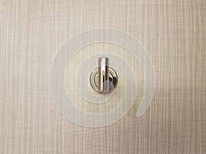 metalic metal coat hook or fixture on grey wall