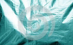 Metalized plastic wrap texture with crumples in cyan color