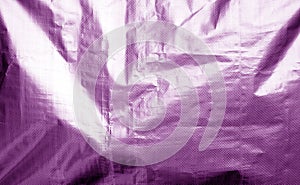 Metalized plastic wrap texture with crumples in purple color
