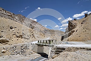 Metall construction bridge across river in mountains