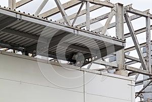 Metallic awning of modern warehouse. Metal framework of roof of industrial premises in enterprise outside view. Structure of steel