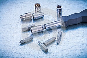 Metallic background with black screwdriver and set