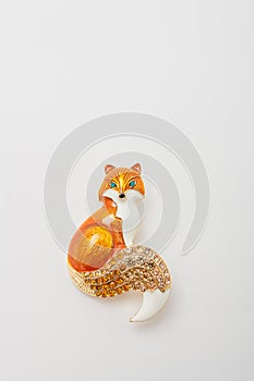 Metallic brooch in shape of fox with orange gemstone imitation, pin isolated on white background, bijouterie, jewelry close up