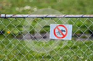 Metallic chain link fence with a bold red and white No Dogs sign