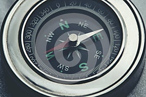 Metallic compass indicating westward direction.