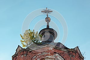 Metallic cross with a Masonic symbol on the dome of an abandoned temple