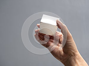 Metallic cube reflecting and shining light on human hand