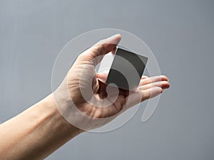 Metallic cube reflecting and shining light on human hand