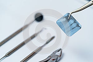 Metallic dentist tools. Dentist instrument sterille. Dental x-ray on white background.