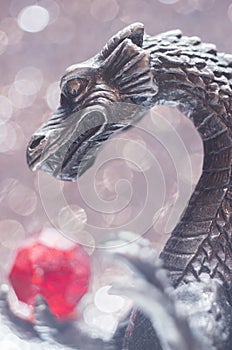 Metallic dragon holding a bead