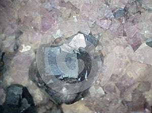 Metallic galena crystal among light purple fluorite