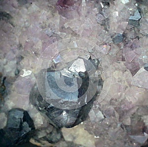 Metallic galena crystal among light purple fluorite