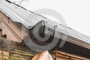 Metallic Guttering System, Guttering, Drainage Pipe Exterior. Drainage on the roof of a triangle log house