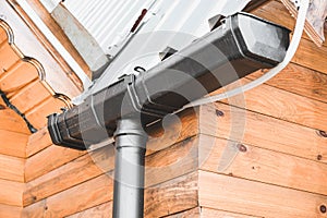 Metallic Guttering System, Guttering, Drainage Pipe Exterior. Drainage on the roof of a triangle log house