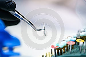 Metallic head for dentist drill. Dentist holds instruments
