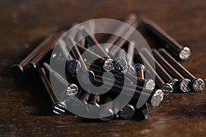 Metallic iron nails in brown table