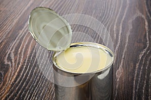 Metallic jar with sweet condensed milk on dark table