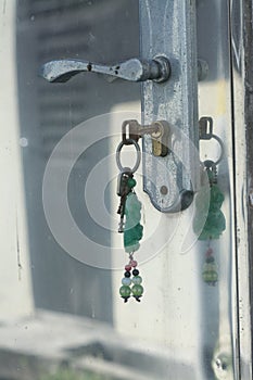 Metallic key-chain stuck on the dirty steel door.