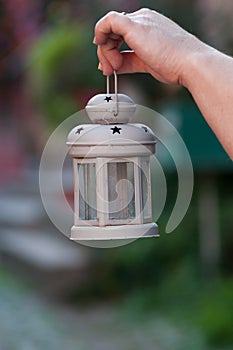 Metallic lantern for garden decoration in hand of wom