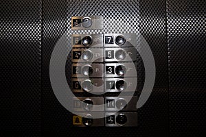 Metallic level buttons in a a dark elevator