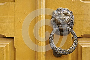 Metallic lion head knocker on a wooden door in Ouro Preto, Brazil