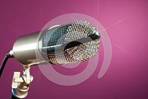 Metallic microphone on pink background