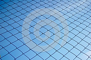 Metallic net with blue sky background