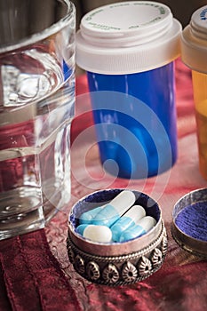 Metallic pillbox with white and blue pills