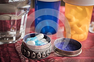 Metallic pillbox with white and blue pills