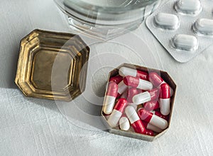 Metallic pillbox with white and red capsules