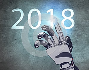 Metallic robot hand touches date of new year 2018.