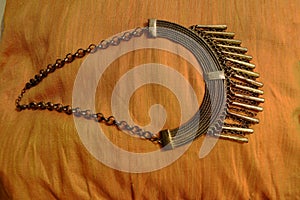 Metallic rustic designed neck less on a yellow background