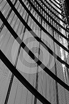 Metallic screen with arched support forming abstract urban facade in black and white