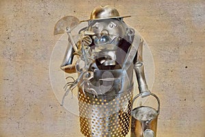 Metallic sculpture of a Steel box man
figure holding a bucket and spade