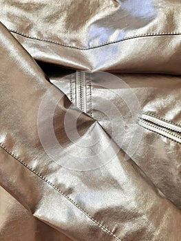 Metallic silver fragment of fashion clothes with zipper. Background design, photography. Textile, fabric template, modern new