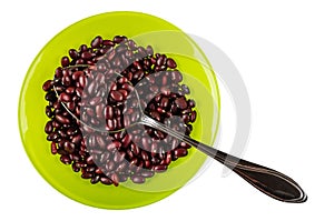 Metallic spoon in bowl with raw red bean isolated on white. Top view